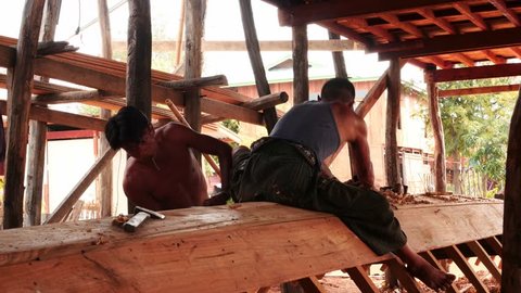March 3 2016 Nyaungshwe, Myanmar. Two workers creating a boat in Myanmar by traditional old methods near Inlay lake 2. Two different angles in one video