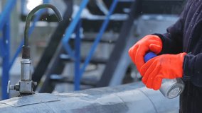 Man on powerful modern mineral oil depot, tank farm. Distiller of crude. Worker takes probe of rock-oil from tap outdoor close up. Test fluid for research of structure, chemical composition of biofuel - Powered by Shutterstock - Get 15% off with code: PIKWIZARD15