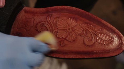 Painting  sole for men shoes. Shoemaker sews shoes