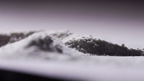Slow motion of hand using credit card to chop cocaine