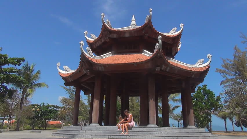 mother and daughter sitting on steps of beautiful Buddhist building with columns