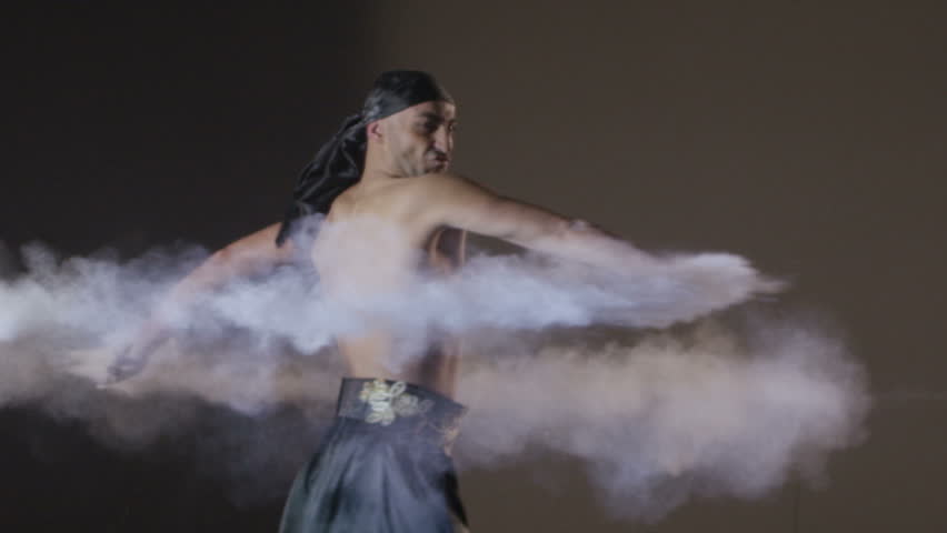 Ethnic Dance.  Man dancing with sand on grey background. Shot on RED EPIC DRAGON Cinema Camera in slow motion.