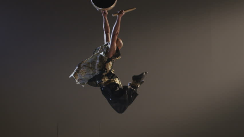 Shaman dancing with a drum on grey background.  Ethnic Asian Dance. Shot on RED EPIC DRAGON Cinema Camera in slow motion.