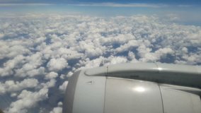 Looking through window aircraft during flight in wing above the clouds.