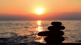 Beach sunset, man build zen symbol from stones on the beach at background of sea and gold sunset, silhouette on the beach. Beach sunset, relax, harmony, balance concept. Hull hd video.