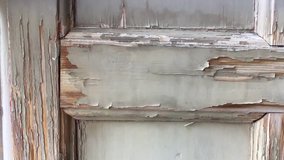 Panning clip of an old wooden panel with peeling paint 