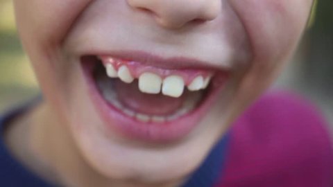 Closeup of cute child mouth smiling and laughing. Real positive emotions of 8 years old boy. Natural lighting. Real time video footage