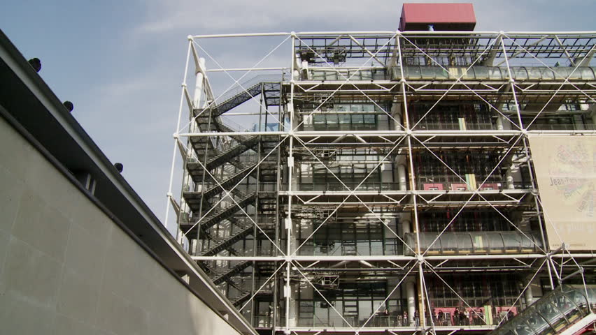 Panning long shot of Metropolitain Train Station to people sitting in square
