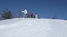 Four young people snowboarding down the hill