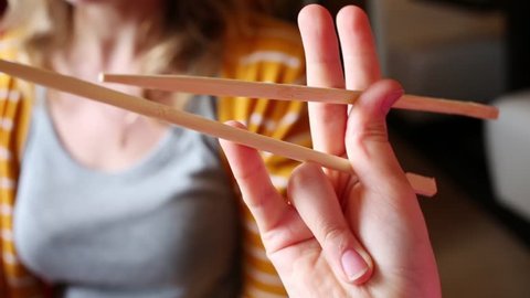 Childs hand with chopsticks close up sushi in restaurant.