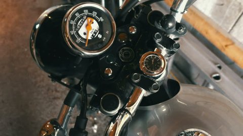First person view of a person putting a key into a motorcycle ignition and turning it on.
