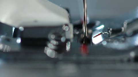 Sewing needle in slow motion. Sewing machine needle work process. Sewing needle working. Sewing machine slow motion. Manufacturing equipment. Process of working of the electric sewing machine