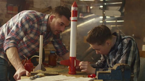 Father and son are modeling a toy rocket in a garage at home. Shot on RED Cinema Camera in 4K (UHD).