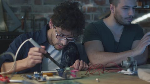 Two students are studying electronics and soldering in a garage. Shot on RED Cinema Camera in 4K (UHD).