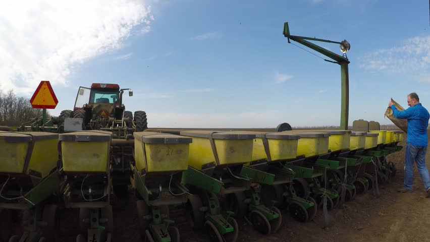 The farmer sleeps grain in a special tractor for planting wheat. Eastern Ukraine.