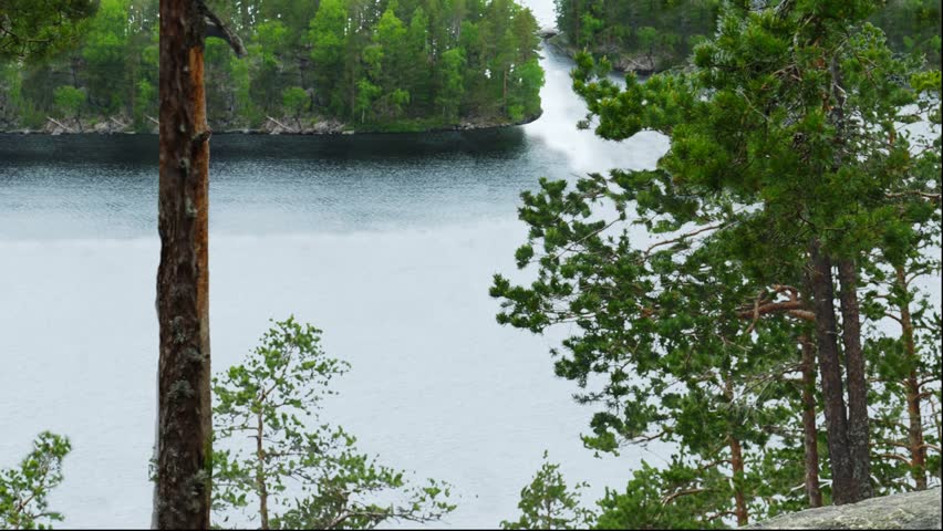 The view from the cliffs over the lake and the boat in the natural Park of Repovesi.Finland./The lake and boat/