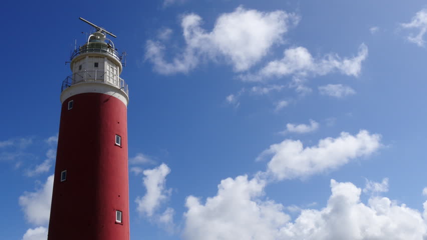 Red Lighthouse standing in the dunes near to the beach. 