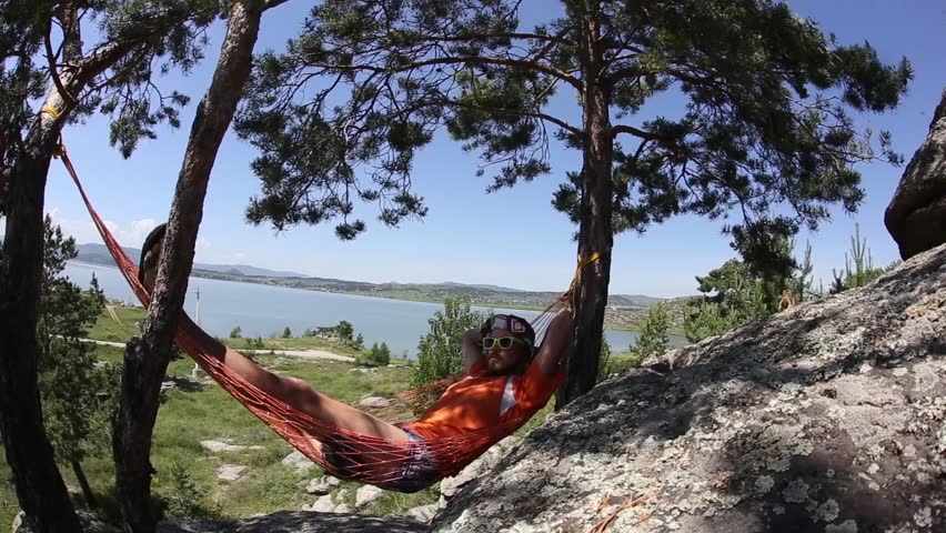 Man relaxing on the hammock in a beautiful day. 