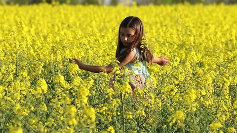 Happy Beauty young girl playing in yellow rape field in rural countryside. Portrait shot, Happy Freedom outdoors concept.