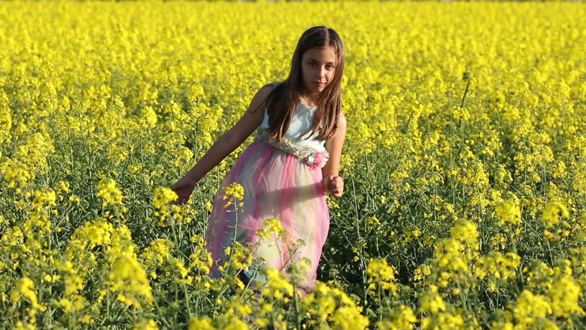 Happy Beauty young girl playing in yellow rape field in rural countryside. Portrait shot, Happy Freedom outdoors concept.
