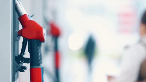 Men's hand using a fuel nozzles at a gas station