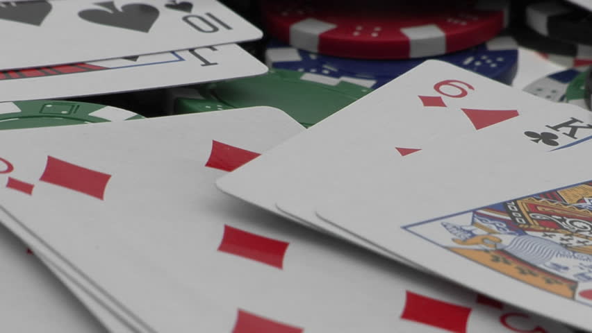 Playing cards and poker chips scattered over a card table