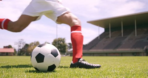 Football player kicking the ball on the football ground Video Stok
