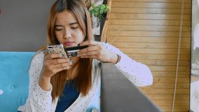Pretty asian girl shopping holding a smartphone and credit card