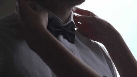 man  corrects businessman bow tie