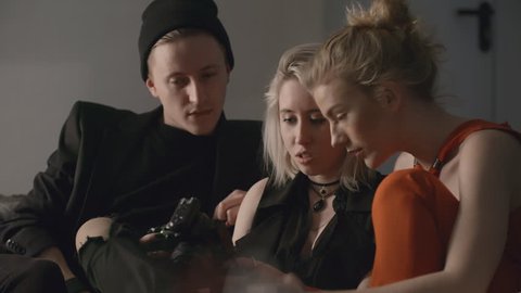 Creative team consisting of photographer, model and stylist looking at photos on camera after photo shooting