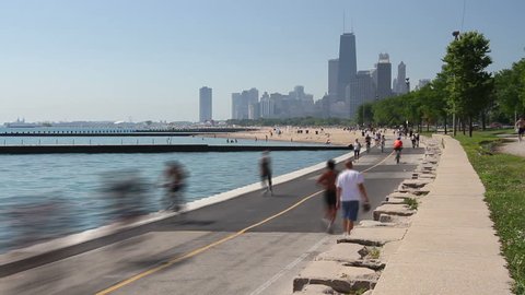 Time lapse of cyclists and runners enjoying a summer day on the Lakefront path along the Lake Michigan shoreline in Chicago. 
