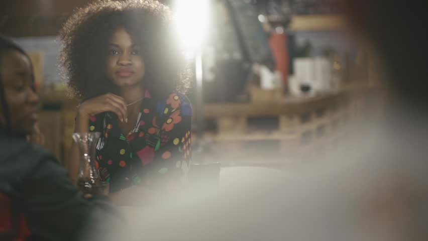 Two remarkable elegant african females having coffee  in the cafe