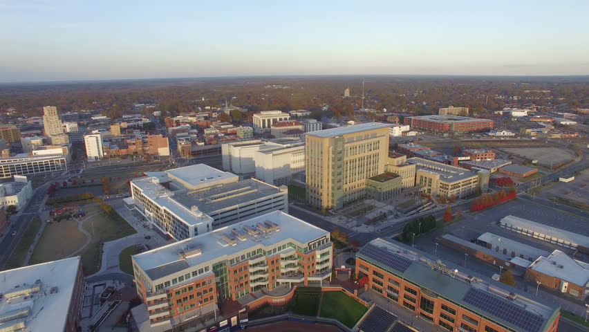Aerial shot easing in towards office buildings in downtown Durham, North Carolina, in evening light. 