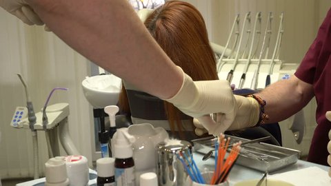 Young Woman in a Chair Dentist Dentistry Procedure, Doctor and Nurse at Work