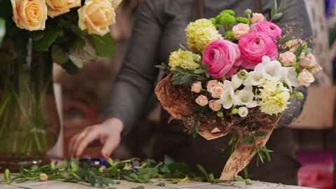 Florist in own flower shop, preparing bouquets. Slow motion