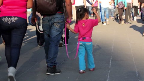 MEXICO CITY-CIRCA MARCH 2016: Parents hold hands to their children while they walk in the park. Nowadays children between 0 and 14 years represent 30% of population in Mexico.