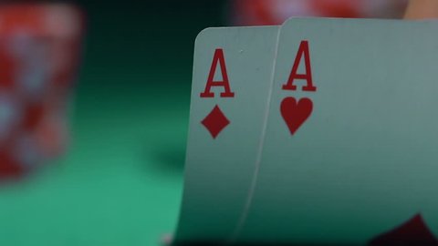 Extreme close-up of poker cards, player checking his hand before making bet. Casino customer playing at table, winning combination strategy, gambling fortune. Lucky tournament winner looking at pair
