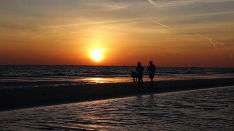 FORT MYERS, FLORIDA April 7th: People walking on the beach at sunset at Fort Myers Beach, Florida on April 7th, 2016 in Ft. Myers, Florida.