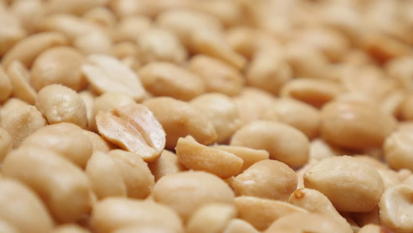 Close-up Arachis hypogaea groundnut slow tilting food background 4K 2160p UltraHD video - Popular snack roasted and salted peanuts pile 4K 3840X2160 UHD tilt footage