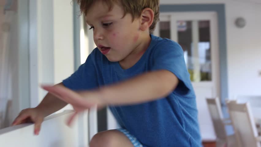 Adorable little boy sitting down on top of a sofa
