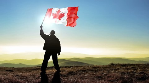 Successful silhouette man winner waving Canada flag on top of the mountain peak, 4k cinemagraph, videoclip de stoc