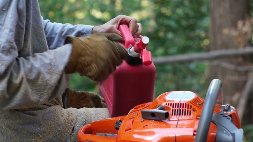 Man puts fuel in chainsaw
