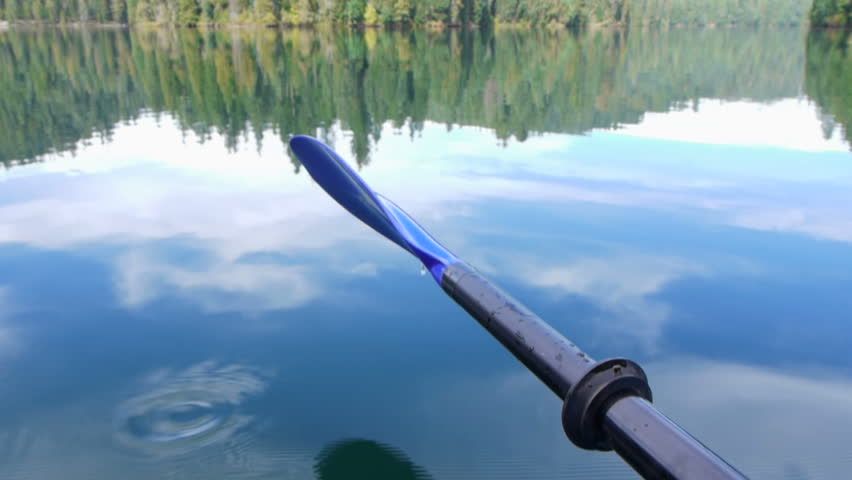 Water drips off kayaking paddle in lake