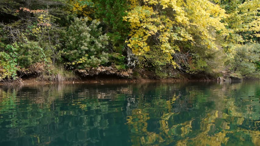 Camera glides across water in a scenic area of northern California during fall