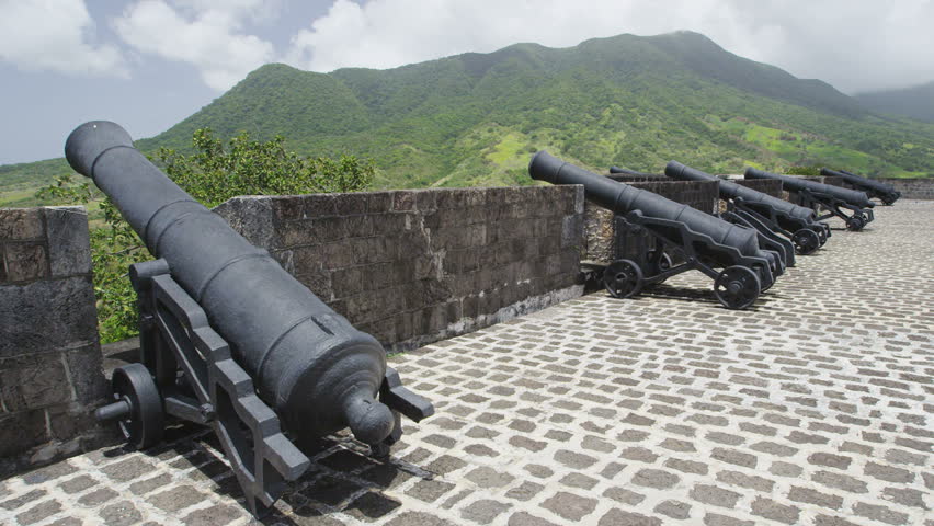 Woman visiting St. Kitts Brimstone Hill Fortress National Park on vacation on St Kitts and Nevis. Caribbean cruise ship tourist destination. Girl walking on cannon lookout on summer travel holidays.
