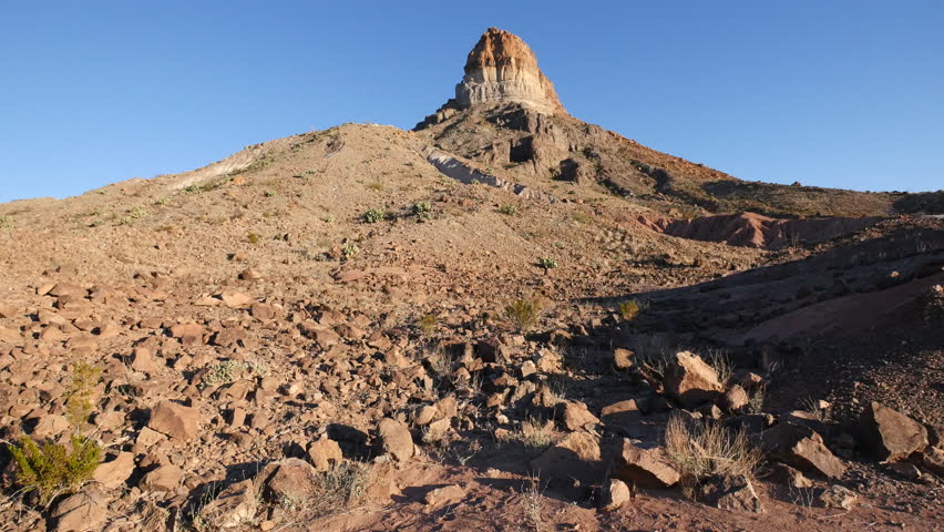 Rock debris extends down a slope crowned with a volcanic rock spire in Big Bend National Park.