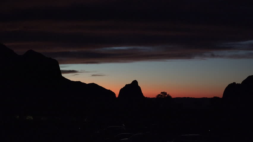 A dark cloud looms over a sunset view of The Window in the Chisos Mountains of Big Bend National Park.