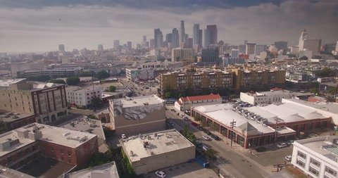 Aerial view of Arts district with downtown Los Angeles skyline in background. Camera flying forward. 4K UHD.