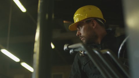 Forklift operator is driving in lumber factory warehouse. Shot on RED Cinema Camera in 4K (UHD).