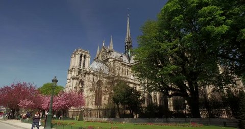 Notre Dame in Paris - France - CIRCA April 2016. View from colorful garden. Dolly shot